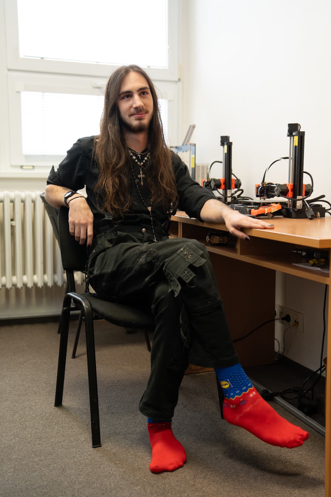 Mathias, student ScioStřední, sedí u stolu s 3D tiskárnami